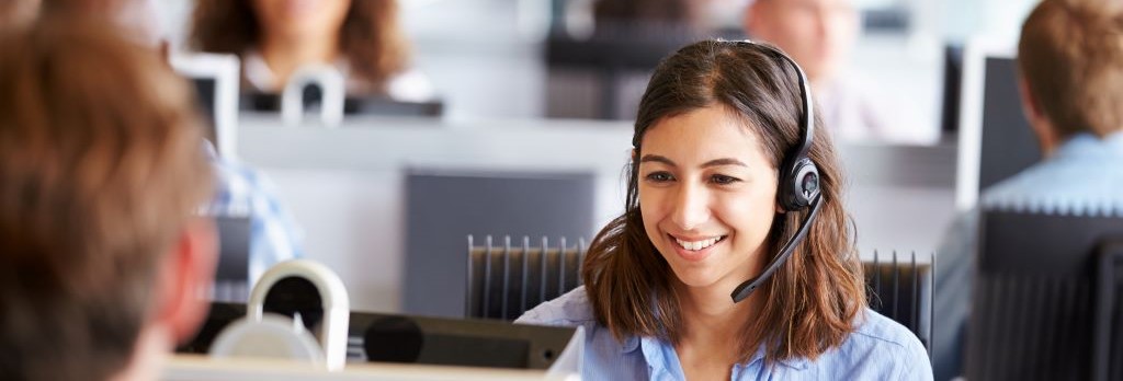 Young woman working in call center, surrounded by colleagues